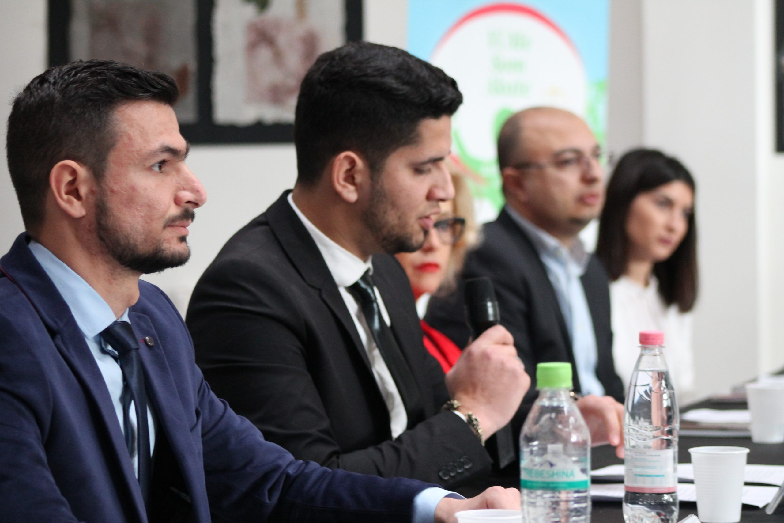 A participant speaking into a microphone during a panel discussion