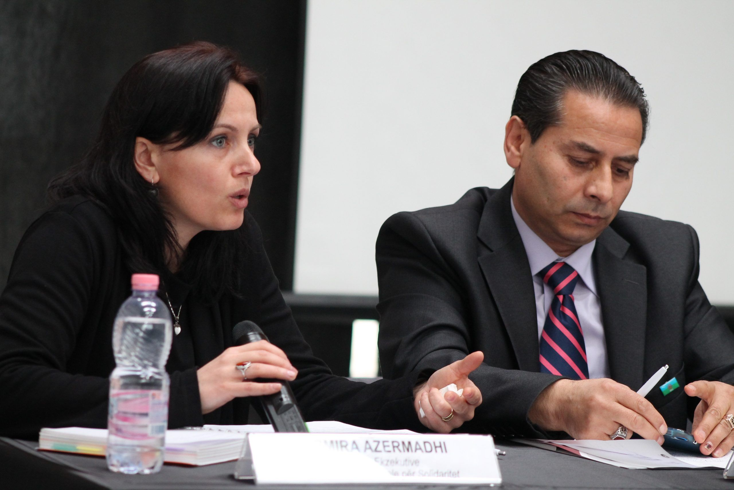 Two panellists in discussion at a roundtable table