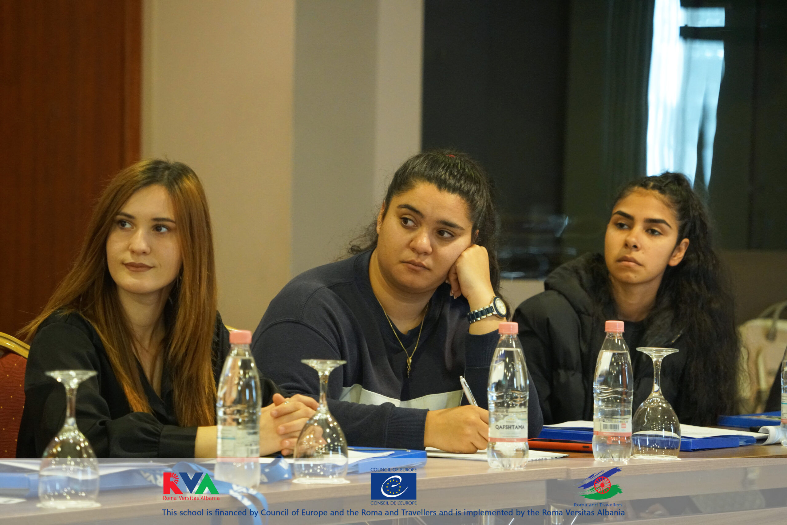 Three students taking notes during a session of the school financed by the Council of Europe
