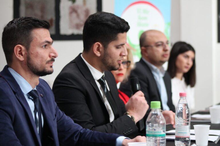 A participant speaking into a microphone during a panel discussion