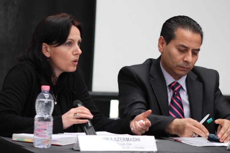 Two panellists in discussion at a roundtable table